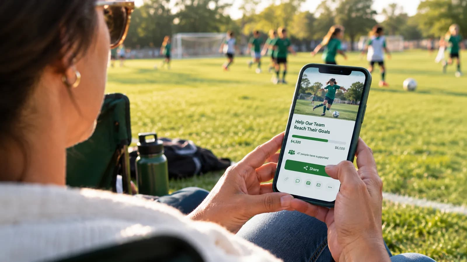 Parent sharing a youth sports fundraising link from a phone at the sideline